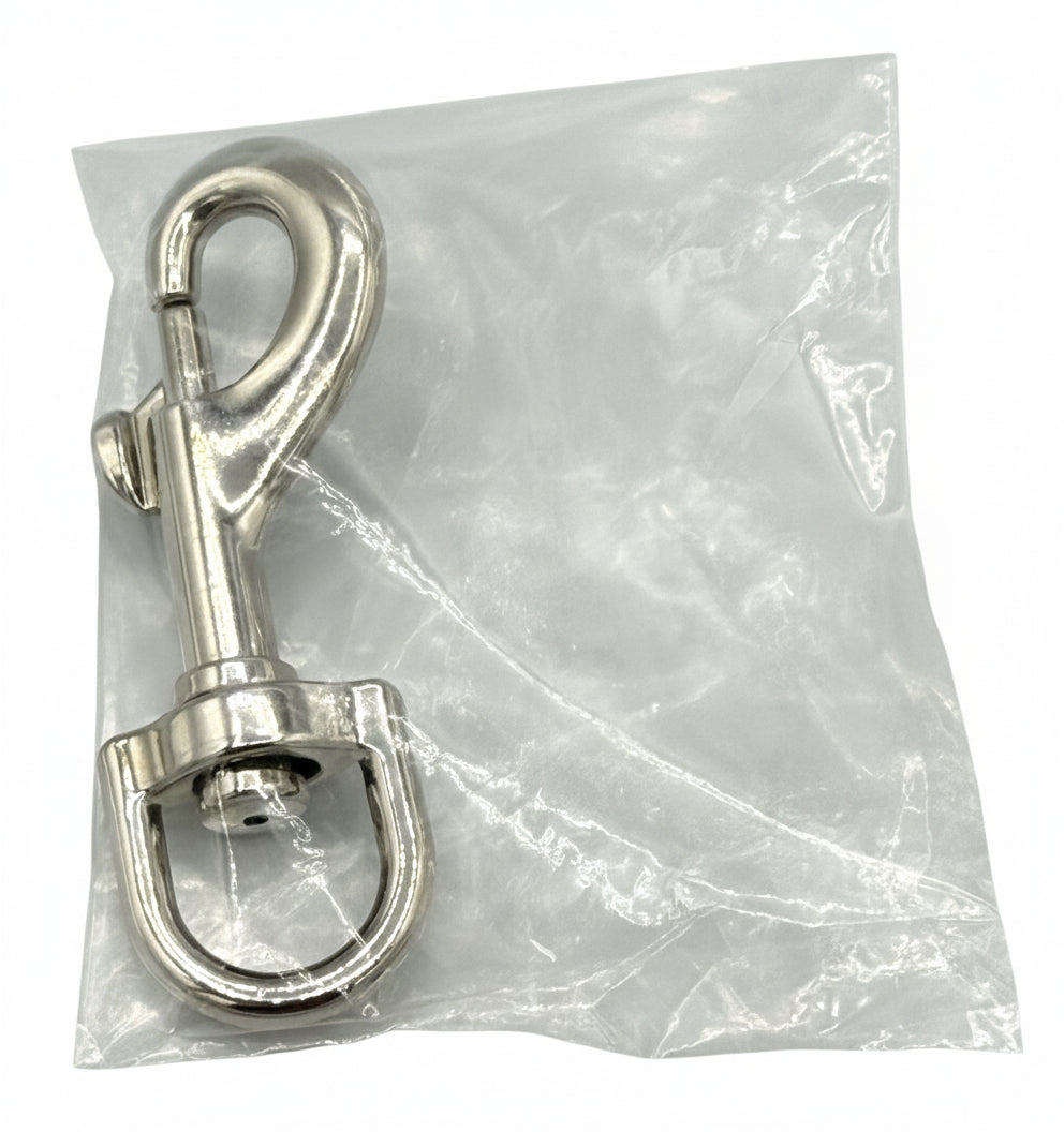 Metallic dog safety clip in a clear plastic bag on a gray background